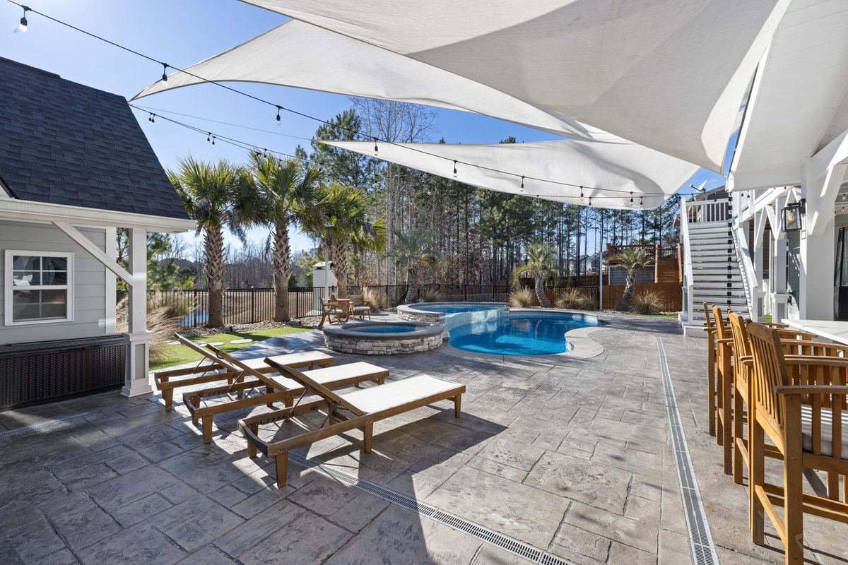 Residential backyard pool and spa with palm trees and shade sails - Fort Myers, FL pool resurfacing service area